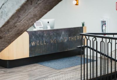 Reception desk with wooden accents and the words Well hello there written on the front.