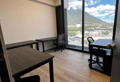 Private office for three with dark wood desks and large windows showing scenic mountain views.