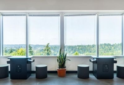 Pair of sleek black standing desks positioned against large windows.