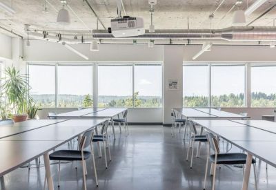 Training or meeting room with multiple rows of tables and a ceiling projector.