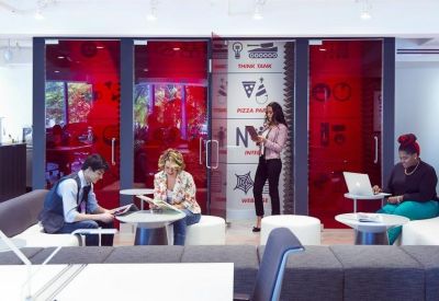 Modern lounge area featuring red glass partitions and white seating pods.