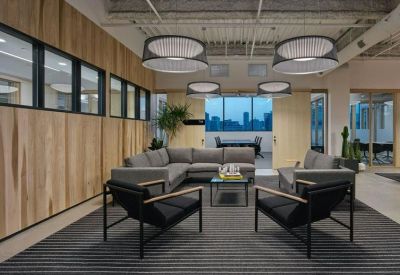 Lounge area with grey sectional sofas, black armchairs, and circular pendant lights.