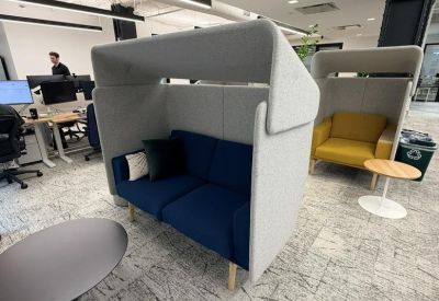 Lounge area featuring high-backed privacy sofas in blue and yellow upholstery.