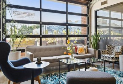 Lounge area at 490 43rd Street featuring a grey sofa and a glass garage-style door.