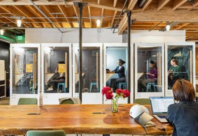 Private glass-enclosed phone booths for focused work.
