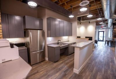 Clean and contemporary kitchen area with stainless steel refrigerator and breakfast bar.