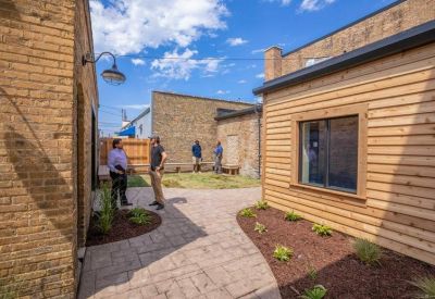 Outdoor courtyard with stone pathways and timber-clad building features.
