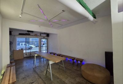 Open workspace with a long table, benches, and a large round ottoman.