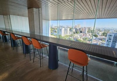 High-top seating area along a glass wall overlooking the city skyline.