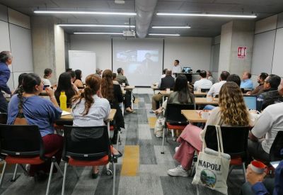 Spacious training room with multiple rows of seating and a presentation screen.