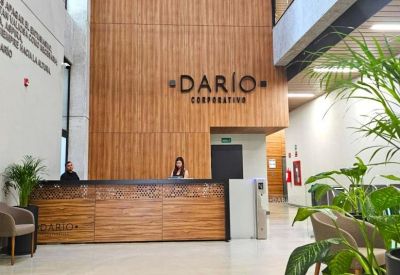 Modern building lobby featuring a wood-paneled reception desk and Dario Corporativo branding.
