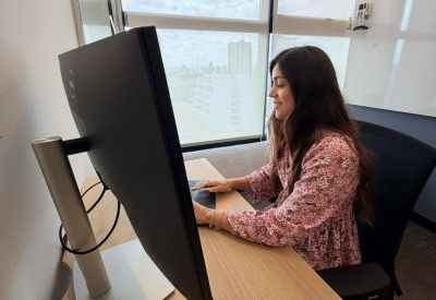Private workstation with a large monitor and view of the city skyline through the window.