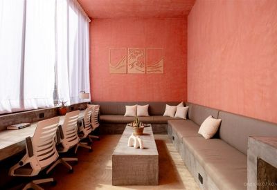 Spacious communal lounge with peach walls and long built-in sofa seating.