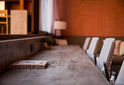 Close-up of a concrete desk surface with white office chairs and a book.
