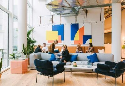 Lounge area with colorful wall art, indoor plants, and comfortable seating.