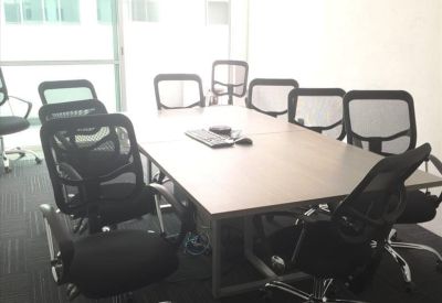Bright conference room with a light wood table and ergonomic mesh chairs.