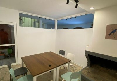 Communal dining and meeting area with a fireplace and modern track lighting.