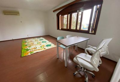 Large sunlit room with hardwood floors and a colorful children's play mat.