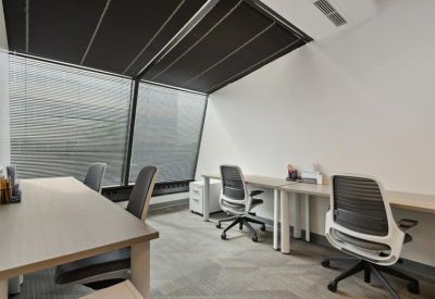 Modern workspace with several desks positioned under a large, angled skylight.