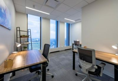 Private office suite with two wooden desks and expansive city views.