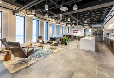 Lounge area with modern leather chairs, area rug, and open ceiling design.