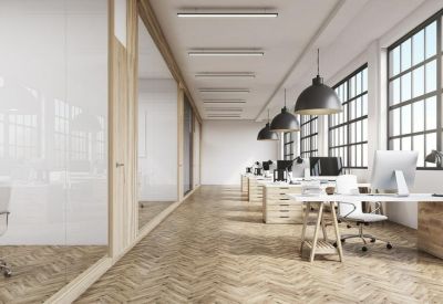 Modern office hallway featuring wood-patterned floors and black pendant lights.