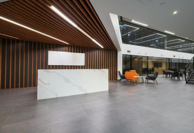 Grand lobby featuring a marble reception desk and wooden slatted ceiling accents.