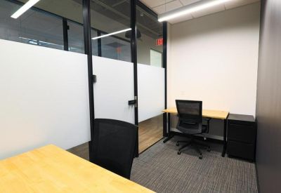 Private internal office suite with two wooden desks and black office chairs.