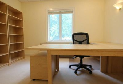 Private office with a desk and empty bookshelves.