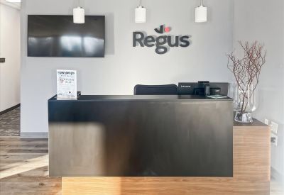 Reception area at 1053 Farmington Avenue, 1st and 2nd Floor, featuring a dark wood desk and branded wall signage.