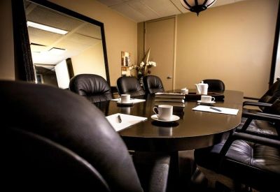 Close-up of a boardroom table set with coffee cups and note pads.