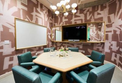 Small conference room with a hexagonal table and patterned wallpaper.
