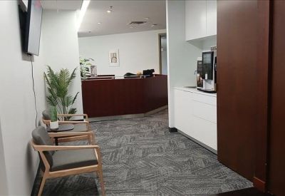 Hallway leading to a reception desk with a coffee station on the right.