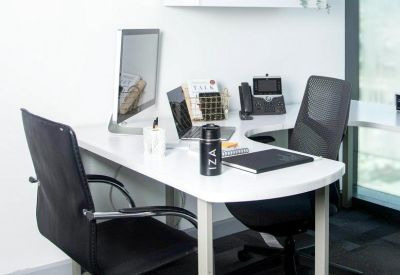 Private two-person office suite with white desks and an overhead storage cabinet.