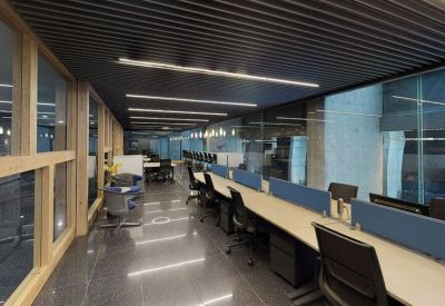 Long rows of modern workstations in a sleek open-plan office with linear lighting.