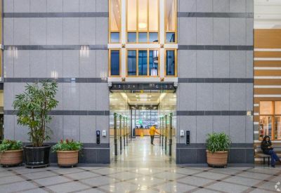 Spacious building lobby featuring security turnstiles and polished stone walls.