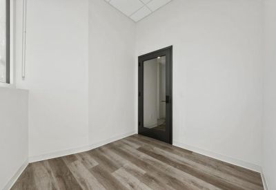Small windowless office space with grey wood-style flooring.