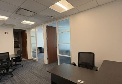 Private workstation area with an L-shaped desk and glass partitions.