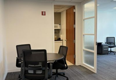 Double glass doors opening into a sunlit corner office suite.