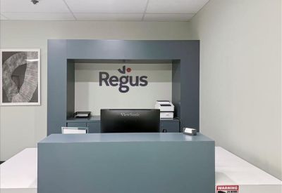 Professional reception desk area with corporate branding on a grey feature wall.
