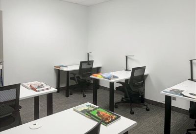 Bright, white private office with four individual workstations and task lamps.