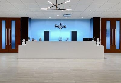 Professional reception desk in a bright lobby with a blue feature wall.