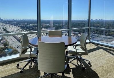Small round meeting table in a corner office with expansive city views.