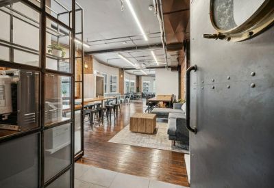 Spacious communal lounge with hardwood floors and industrial accents.