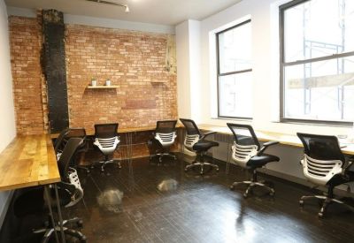 Private office with exposed brick walls and six ergonomic workstations.