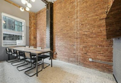 Modern conference room with an exposed brick wall and large windows.