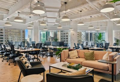 Sophisticated lounge area with plush armchairs, marble coffee tables, and a wooden bookshelf.