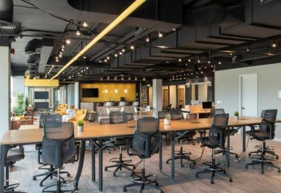 Spacious open-plan workspace with long communal tables.