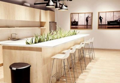 Breakout kitchen area featuring a light wood island with built-in planters.