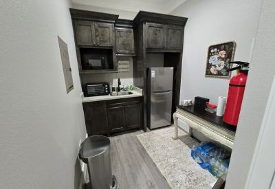 Compact breakroom with dark cabinetry, microwave, and mini-fridge.